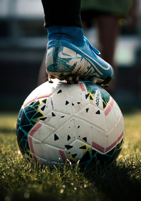 white and blue soccer ball on green grass field
